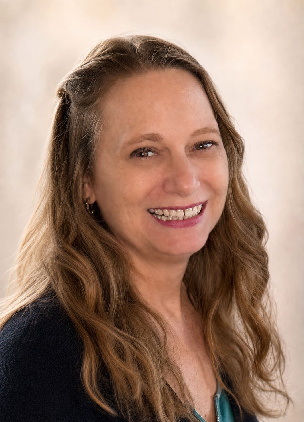 headshot of Debbie smiling at the camera wearing a black sweater